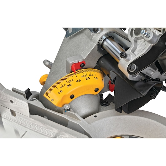 Close-up view of the angle adjustment scale on a DEWALT DWS780 miter saw, showing the yellow protractor gauge and adjustment mechanism.
