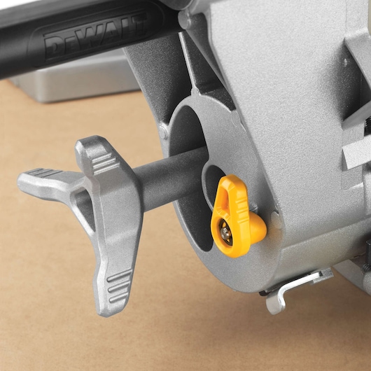 Close-up of a DEWALT DWS780 miter saw component, showing a silver handle and a yellow adjustment knob attached to the metal body.