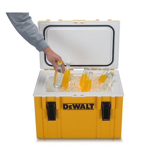 A yellow DEWALT cooler with an open lid, filled with ice and glass bottles. A hand is taking one of the bottles out of the cooler.