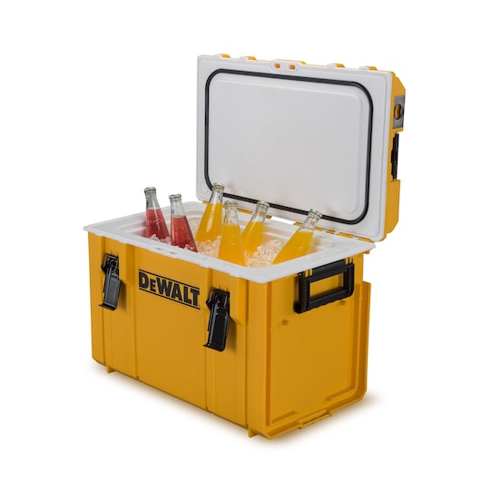 A yellow DEWALT cooler box with an open lid, filled with ice and several glass bottles of red and orange beverages.