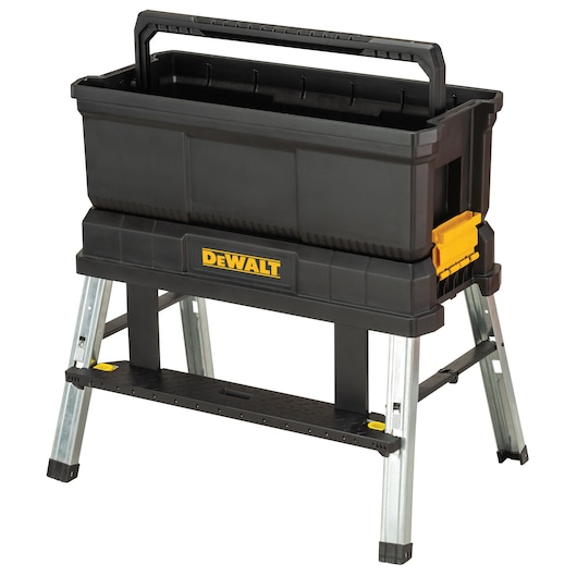 A black Dewalt toolbox with a sturdy handle is mounted on a metallic folding stand. The toolbox features yellow accents and the Dewalt logo on the front. The stand provides stability and elevates the toolbox for easier access.