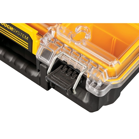 Close-up of a DEWALT ToughSystem organizer, showing the transparent plastic lid, yellow internal compartments, and a sturdy black latch.