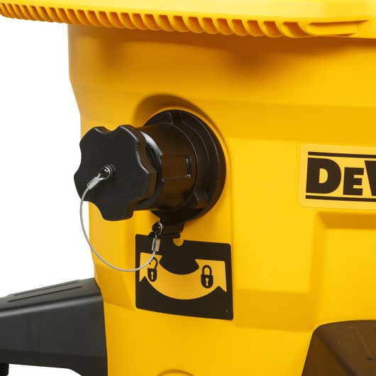 Close-up of a yellow DEWALT machine with a black locking knob attached to the side. There is a wire loop connecting the knob. A locking instruction sticker is visible below the knob.