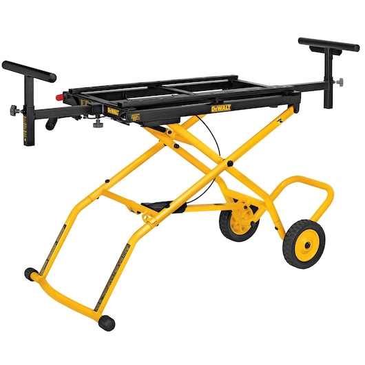 A DEWALT DWX726 yellow rolling workstation stand with adjustable supports and black frame, designed for mounting tools such as miter saws. The stand has two large wheels for mobility, folding legs, and extended handles for tool support.