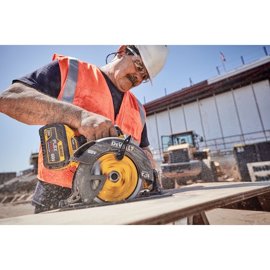 20 Volt to 60 Volt 9 AMP hours Lithium-Ion Battery-powered Circular Saw being used by a construction worker to cut a wooden sheet at a construction site