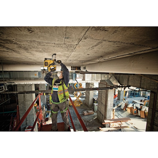Brushless, cordless SDS PLUS L-shape rotary hammer being used by a person