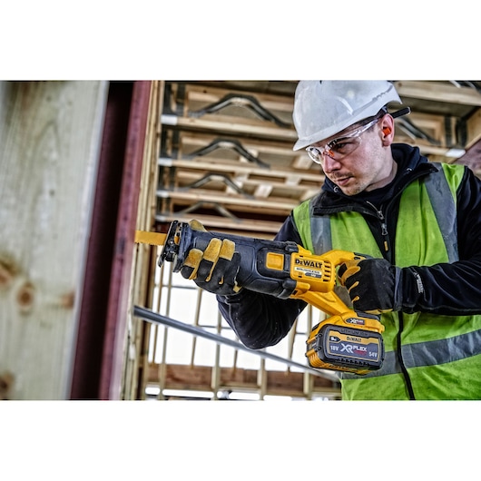 FLEXVOLT brushless cordless reciprocating saw being used by person.