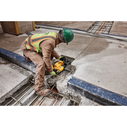 Overhead view of  Dust extractor being used by a person to drill.