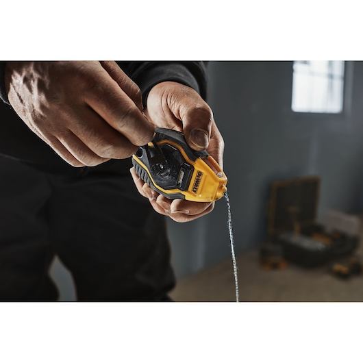 Person rewinding DEWALT ATOMIC COMPACT SERIES Chalk Reel