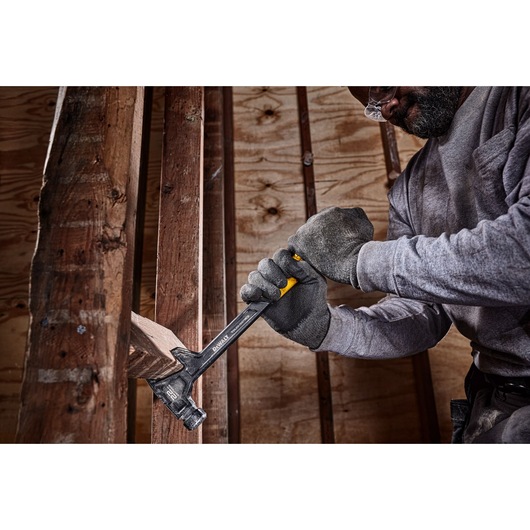 22 ounce demolition hammer being used remove a block of wood from between two long columns.